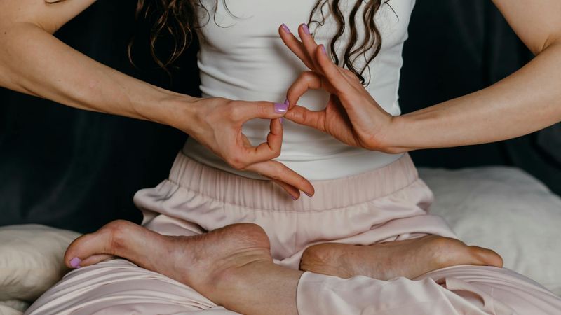 Person demonstrating a deep breathing exercise with hands in a mudra.